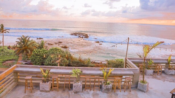 A beachside terrace with seating and potted plants, overlooking the ocean. - Cozy Cocos (Weligama)