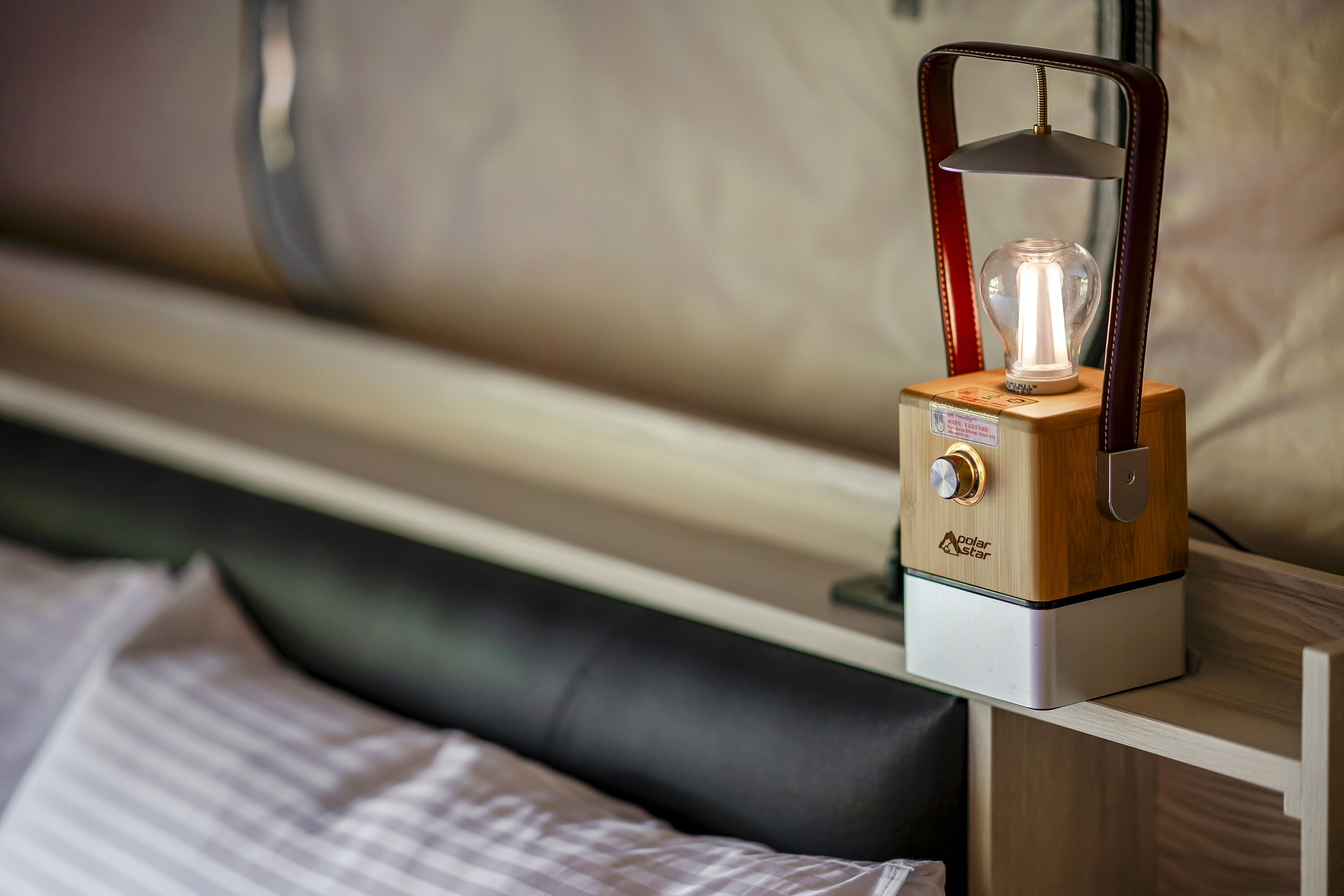 A wooden bedside table with a solar-powered lamp on it.