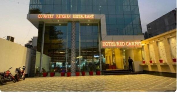 A modern building with a glass facade, labeled "COUNTRY KITCHEN RESTAURANT" and "HOTEL RED CARPET" on the signage. - Hotel Sahibs Red Carpet (Agra)