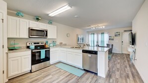 A modern kitchen with white cabinets, stainless steel appliances, and a central island. - Gulf Cost Home 5min to I-75 & Sunseekers Resort (Port Charlotte)