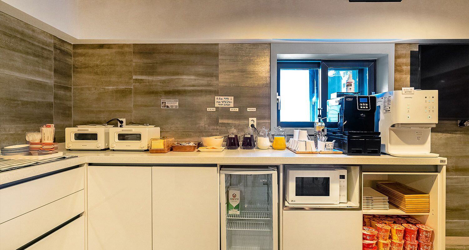 Una cocina moderna con electrodomésticos integrados, cafetera y minibar.