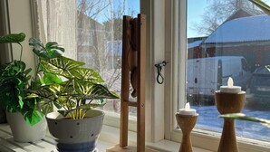 Un rebord de fenêtre orné de plantes en pot, un chevalet en bois, des bougeoirs et des clés.