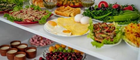 A buffet with various dishes including salads, eggs, and desserts.