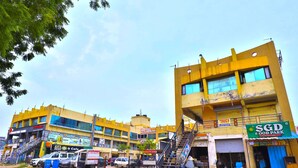 A multi-story building with various businesses, including a hotel, a food park, and a cafe. - Hotel Nilkanth (Ahmedabad)