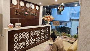 A hotel reception desk with clocks displaying times from New York, London, Hong Kong, Seoul, and Tokyo. - Sen Hotel by Bay Luxury (Hanoi)