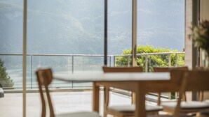 A dining area with a view of a lake and mountains.