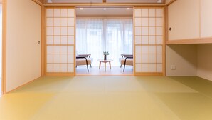 A traditional Japanese room with tatami flooring, sliding doors, and a small table with chairs. - Stagione Hakone Yumoto Villa (Hakone)