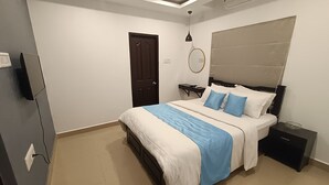 Un dormitorio moderno con cama, mesitas de noche, un espejo y una puerta.