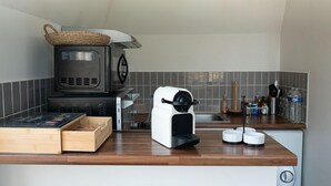 A compact kitchen with a microwave, toaster, and a small sink. - Un Appartement Dans un Château (Deauville)