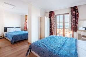 Ein Hotelzimmer mit zwei Betten, einem Kleiderschrank und Blick auf die Stadt.