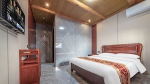 Un dormitorio moderno con una cama de madera, un pequeño armario de madera y un espejo grande.