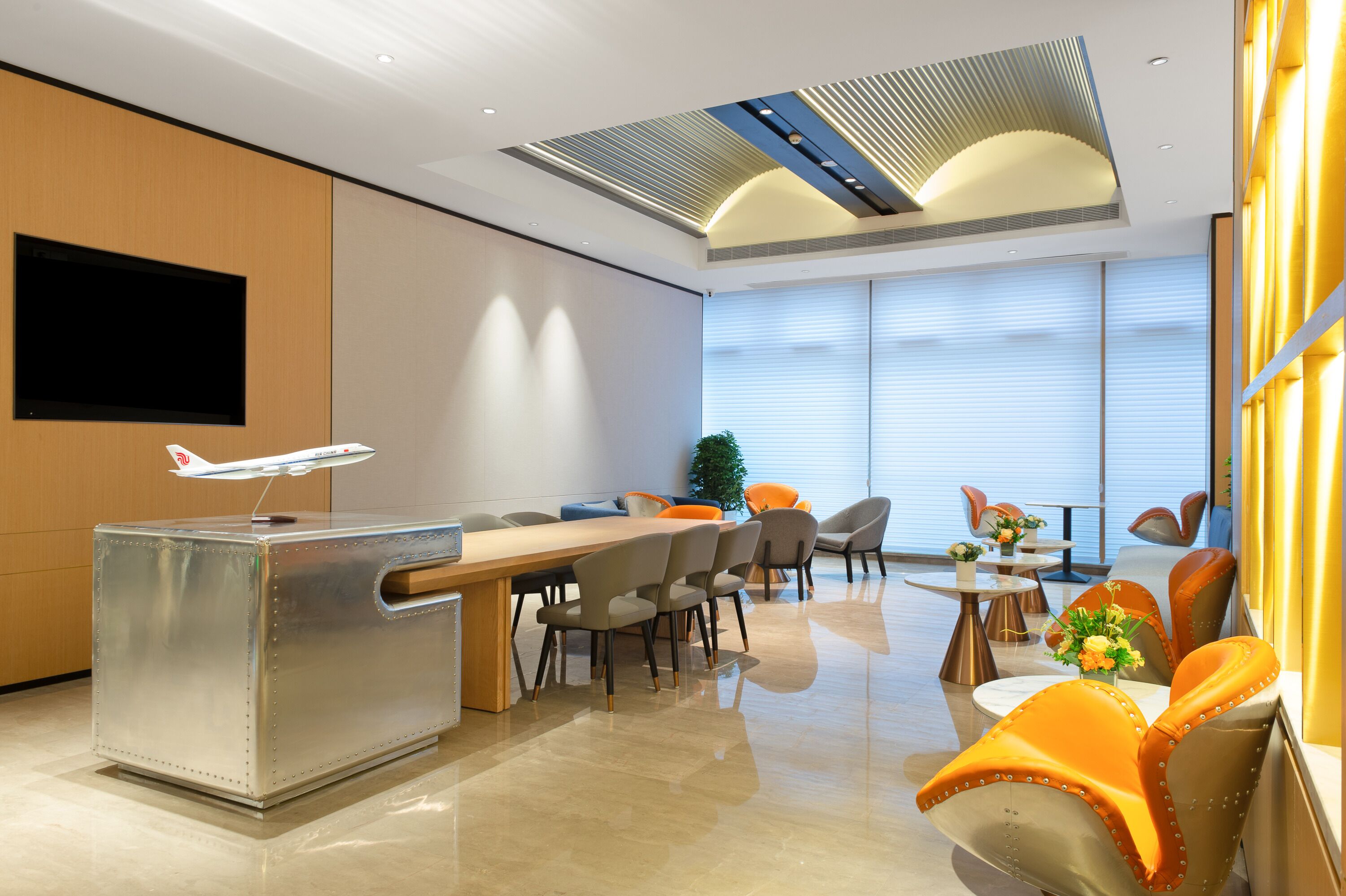 A modern hotel lobby with a reception desk, seating area, and large windows.