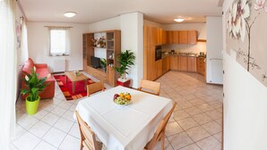En kompakt bolig med spiseplads, køkken og et lille opholdsområde.