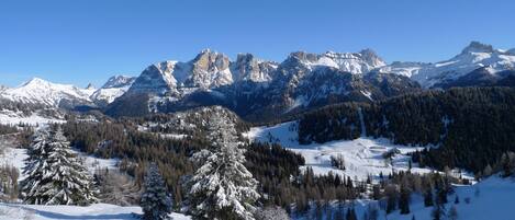 Un paisaje montañoso cubierto de nieve con cielos despejados.
