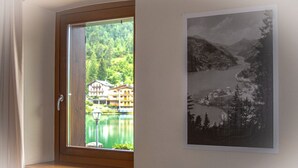 A window with a view of a lake, buildings, and a mountain landscape.