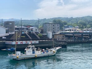 A boat docked at a harbor with a bridge and buildings in the background. - Seaside Harbor Odawara (Odawara)