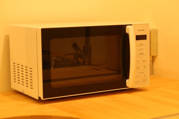 A microwave oven with a digital display and control panel, placed on a wooden surface. - Seaside Harbor Odawara (Odawara)