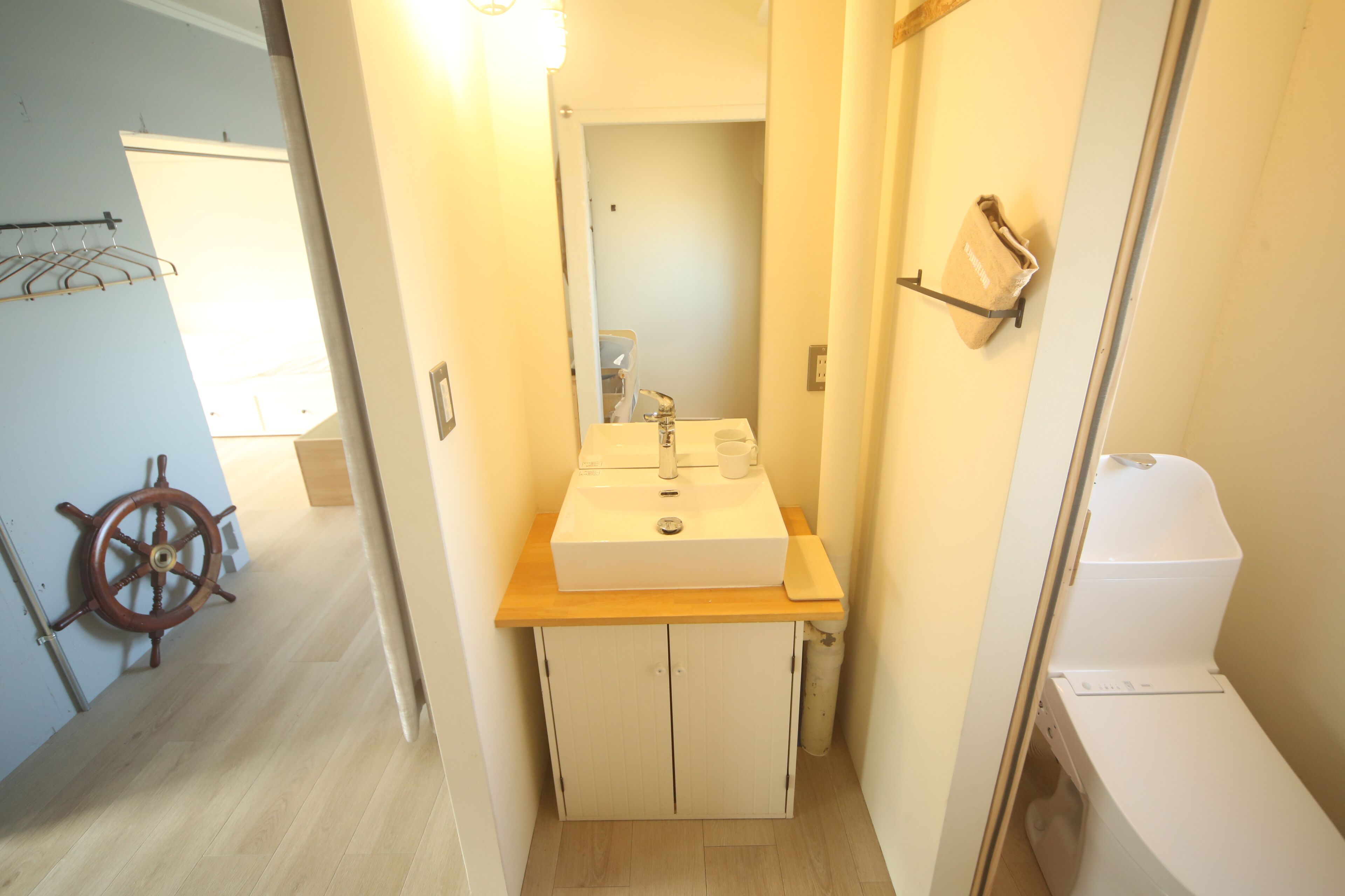 Un baño con lavamanos, espejo e inodoro.