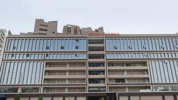 Een meerhoog hotel met een modern architectonisch ontwerp, met een opvallend 'HOTEL' bord en 'NARODA ICON' branding.