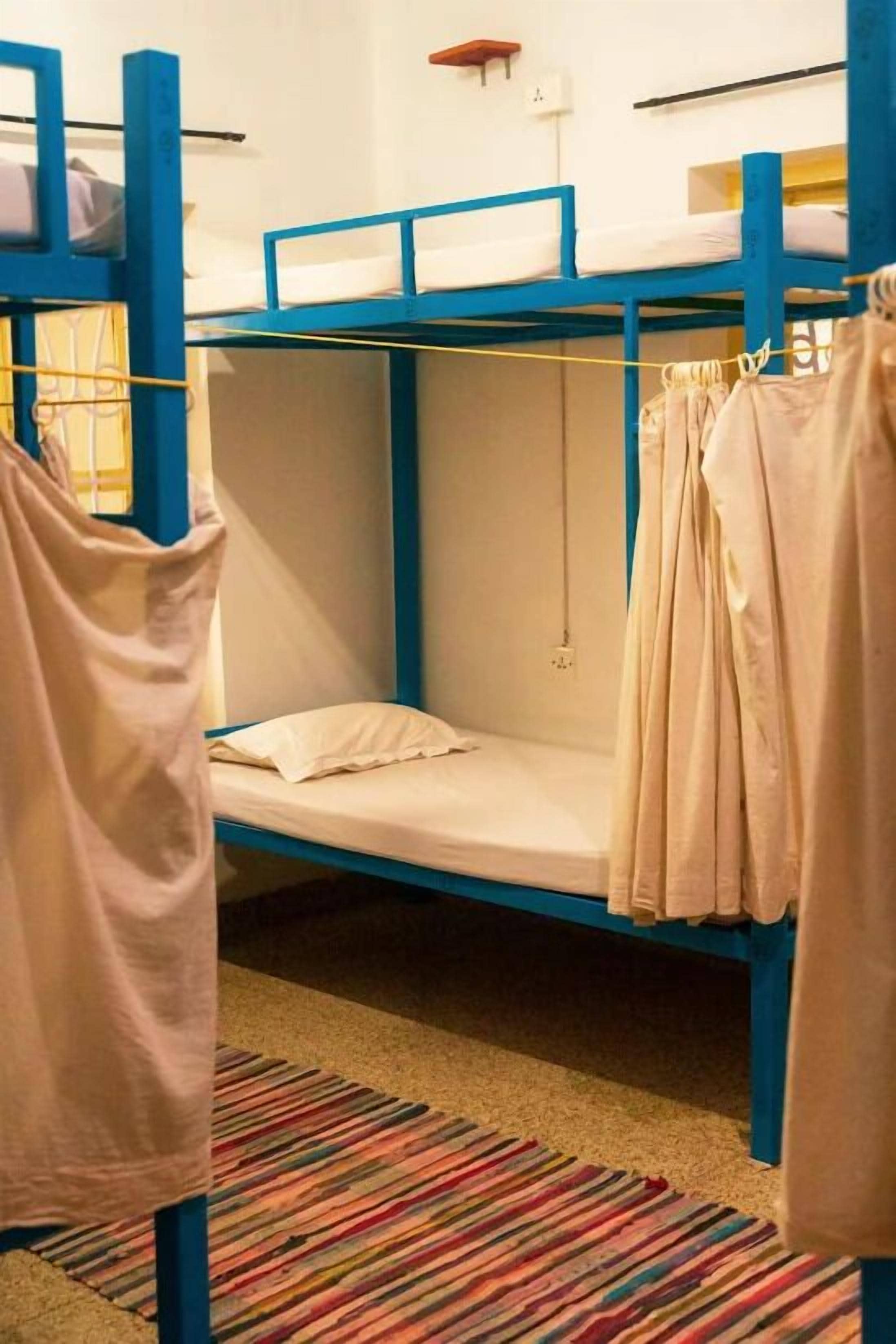 A bunk bed room with a striped carpet and a hanging garment.