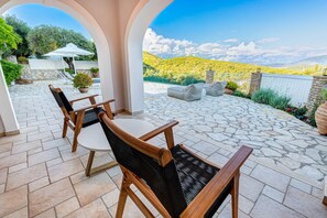 A patio with stone flooring, outdoor furniture, and a view of a mountainous landscape.