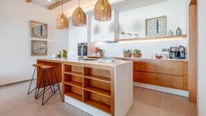 A modern kitchen with a central island, pendant lights, and wooden cabinetry.