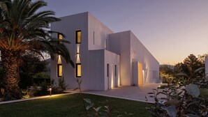 Un edificio moderno con techo plano, amplios ventanales y un césped cuidado.