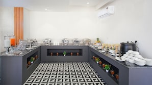 A buffet setup with various food and drink stations, including a coffee maker and a large black pot on the right. - Rishivan Hotels and Wellness (Dasada)