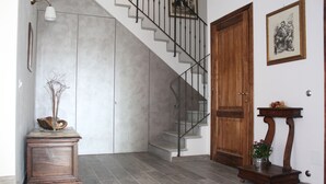 Una scala con ringhiera in metallo, una porta in legno e un piccolo tavolo con una pianta.