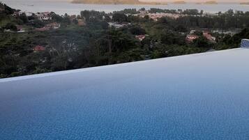 Una piscina al aire libre, sombrillas, sillones reclinables de piscina