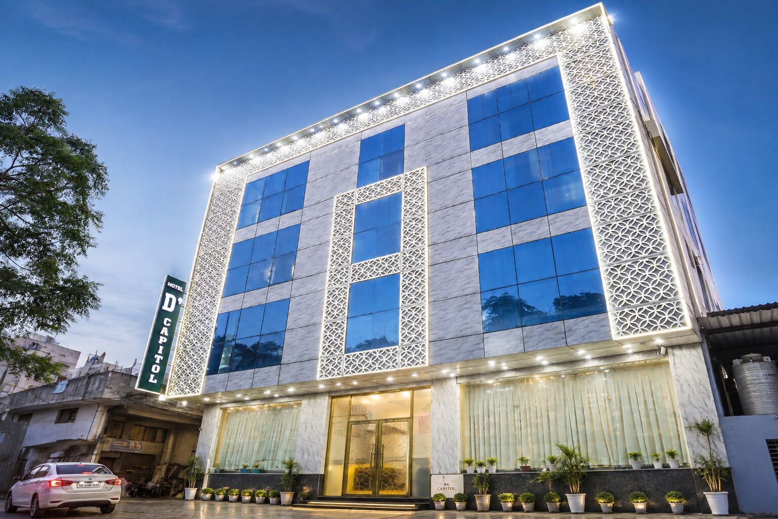A modern hotel building with a prominent 'H' logo, large windows, and a decorative facade.