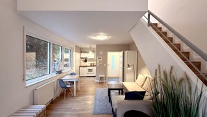 Een modern interieur met een eethoek, keuken en trap.