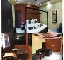 Una habitación con una cama con dosel, una mesita con sillas, un sofá y un espejo.