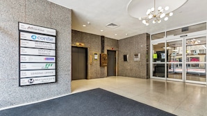 A hotel lobby with a sign indicating various floors and amenities, including residential apartments, a rooftop terrace, and a leasing office. - Stay in the Heart of Downtown! (Baton Rouge)