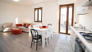 Un appartement moderne comprenant un coin repas, une cuisine et un salon.
