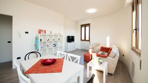 Un salon moderne avec un canapé, une table à manger et un téléviseur.