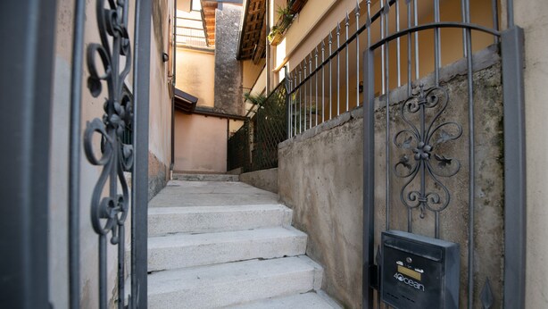 Un escalier en pierre mène à une entrée fermée par un portail, à côté de laquelle se trouve une boîte aux lettres portant l’inscription « 40, avenue de l’Océan ».