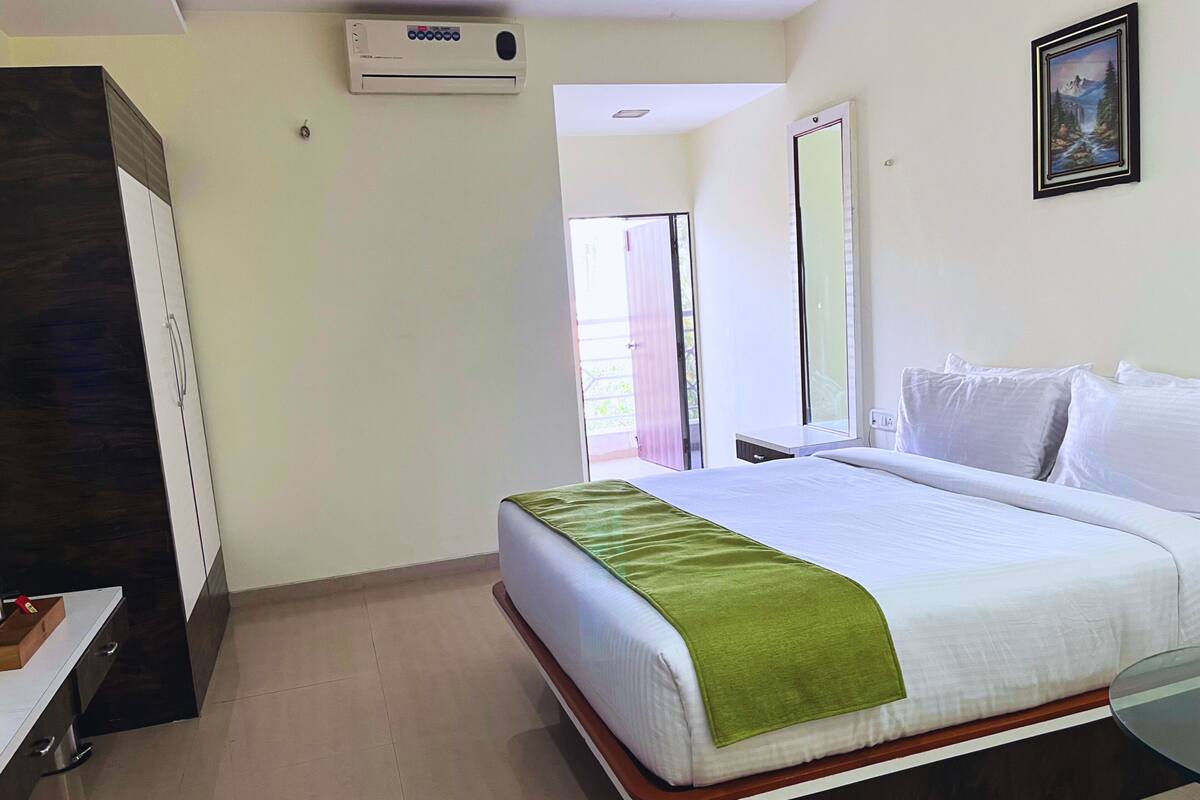 Une chambre d’hôtel avec un lit, une armoire, un bureau et une fenêtre.