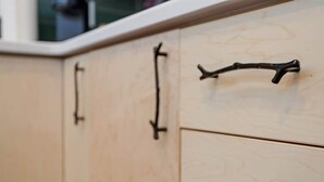 A wooden cabinet with black handles. - Chic Downtown Raleigh Tiny House (Raleigh)