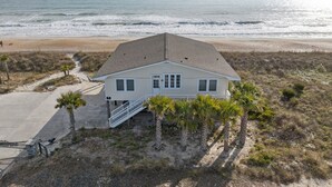 A beachfront house with a large balcony, a staircase, and a view of the ocean. - The Sundance Cottage (Wrightsville Beach)