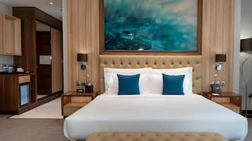 A modern hotel room with a large bed, two nightstands, a desk, and a wardrobe.
