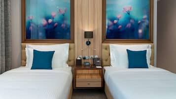 Habitación de hotel con dos camas, cabecero de madera, mesita de noche con lámpara, teléfono y reloj marcando las 3:29.