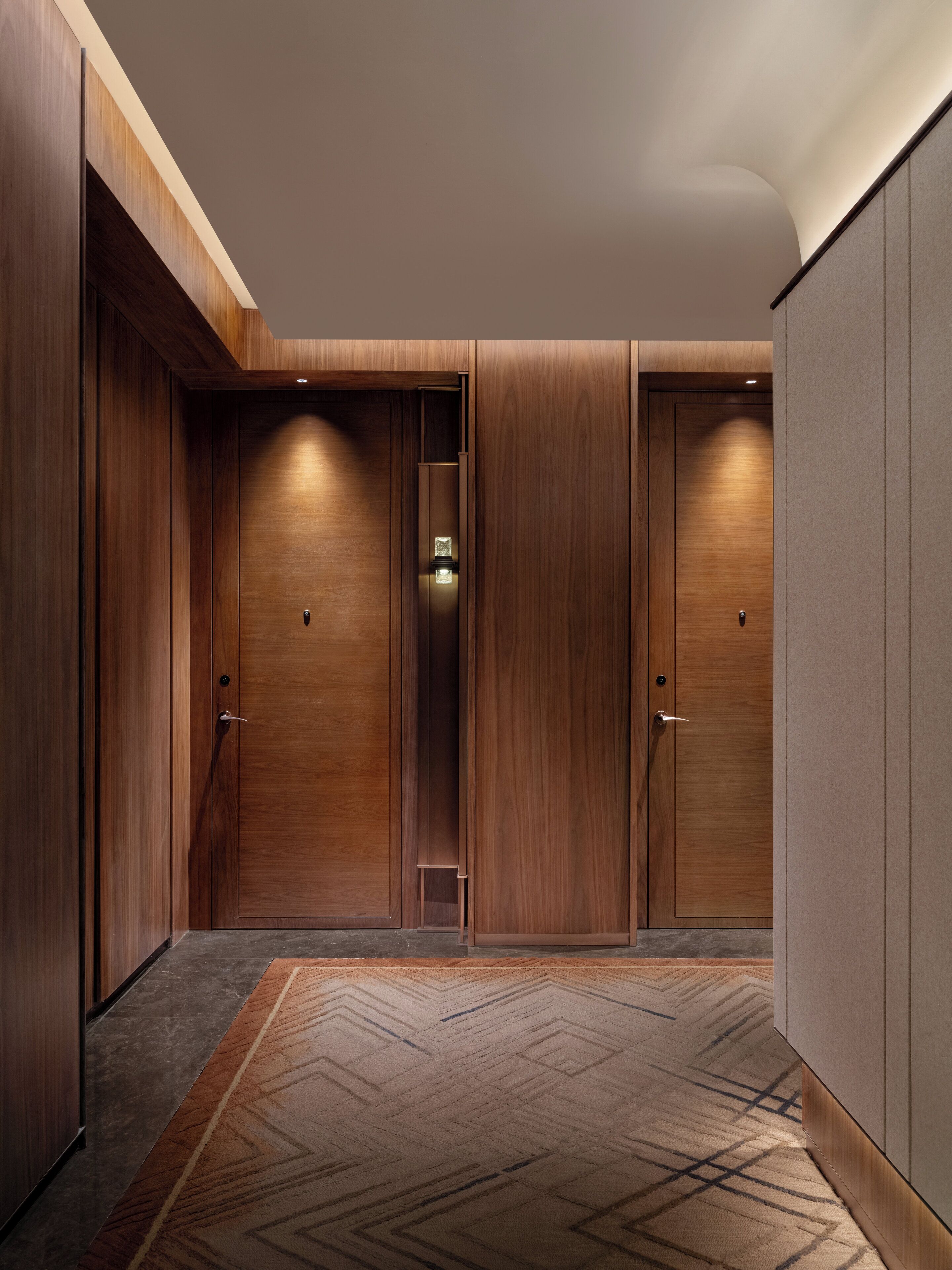 A hallway with wooden doors and a carpeted floor.