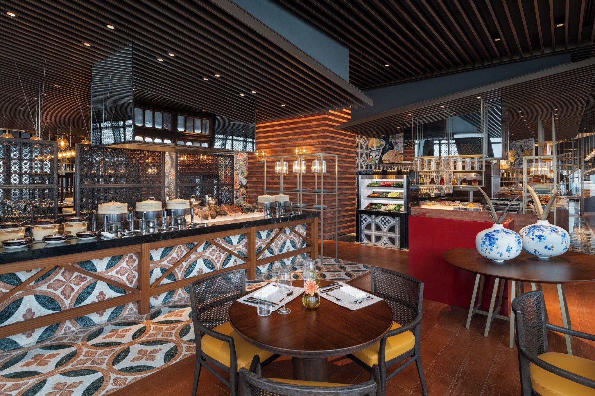 A modern restaurant interior with a central bar area, seating arrangements, and decorative elements.