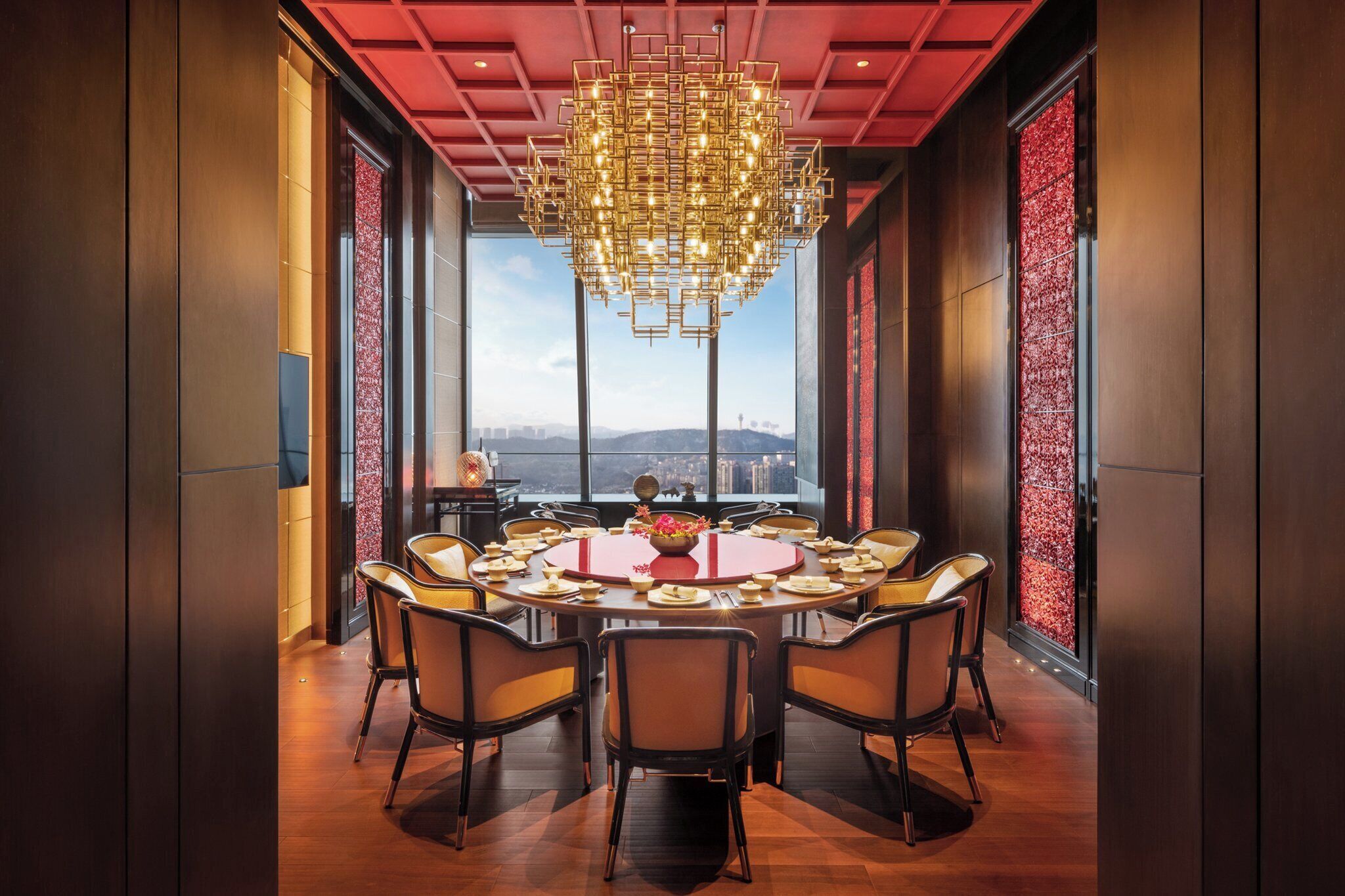 A conference room with a round table, chairs, and a chandelier.