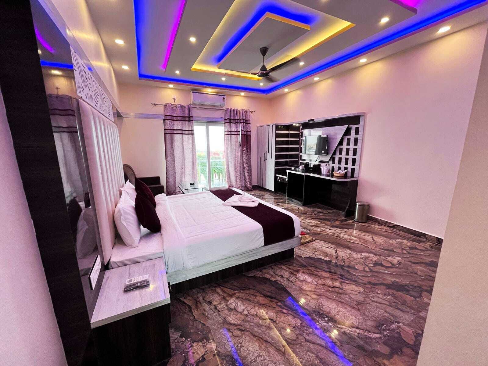 Quarto de hotel moderno com cama, escrivaninha e televisão.