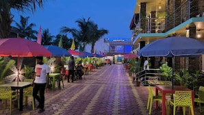 A paved pathway leading to a building with a sign reading "The Beach Resort & Spa". - The Pelican Beach Resort Mandarmoni (Kanthi)
