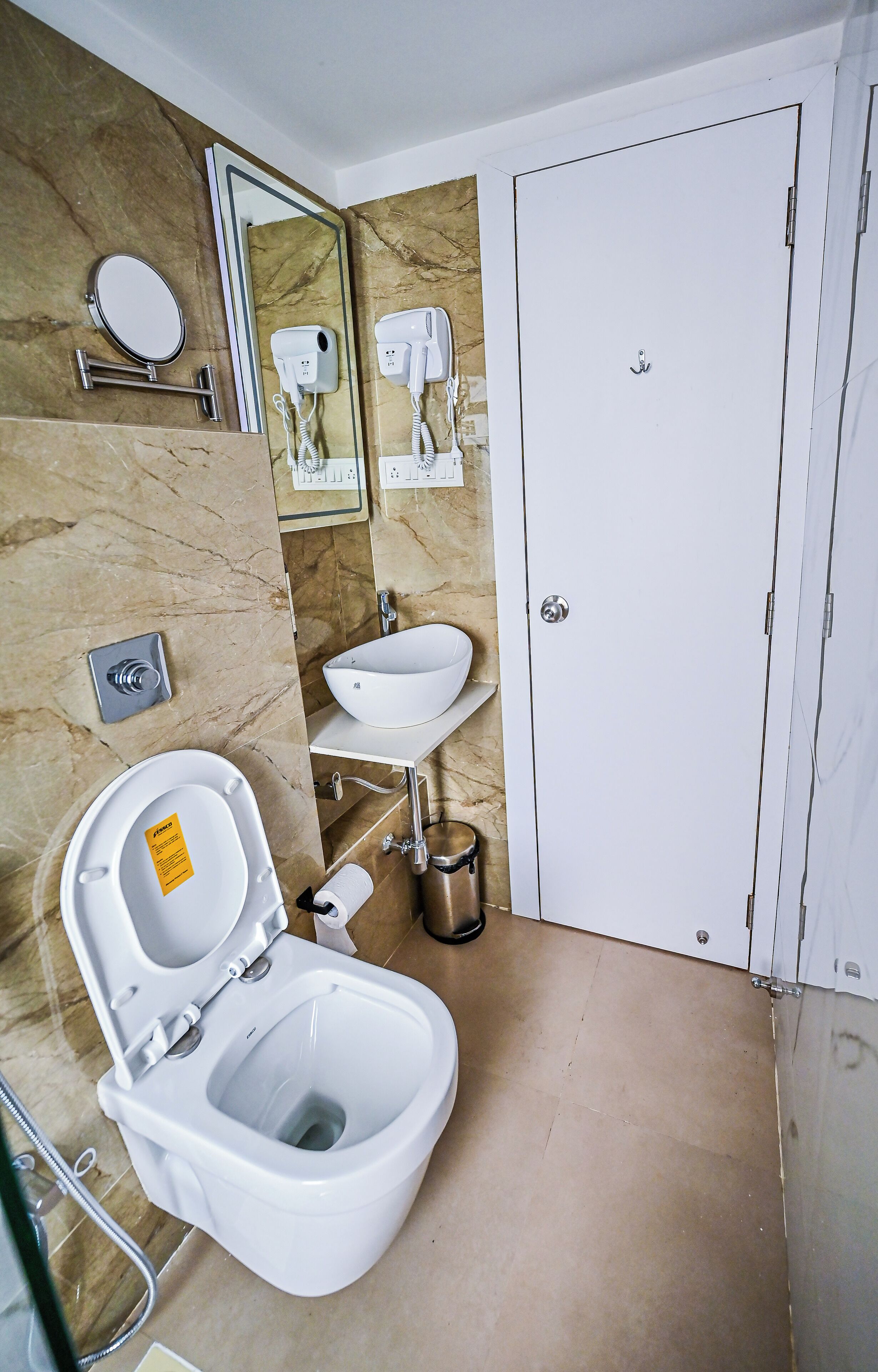 A bathroom with a toilet, sink, and a mirror.