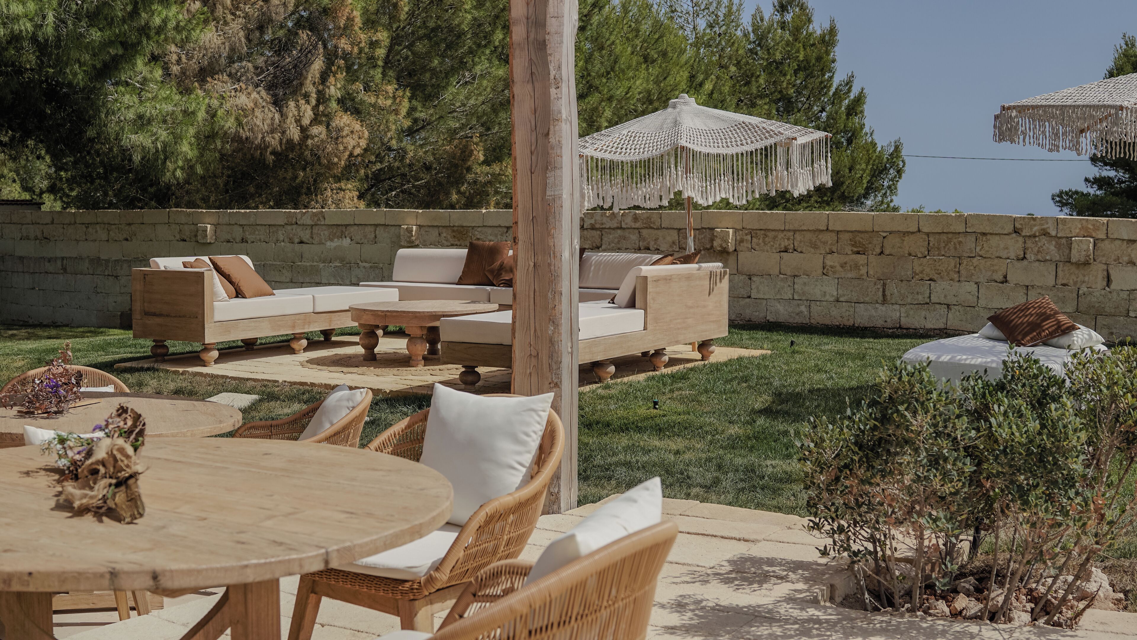 An outdoor seating area with wicker furniture, a round table, and a canopy.