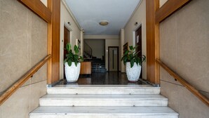 A marble staircase with wooden handrails leading to a landing.